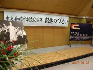 会場に飾られた席先生の写真と赤い薔薇の花・中央合唱団旗